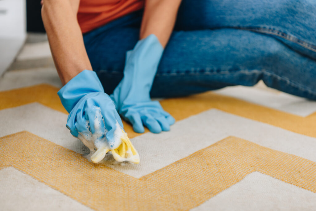 Woman removing a spill because she knows how to clean carpet stains