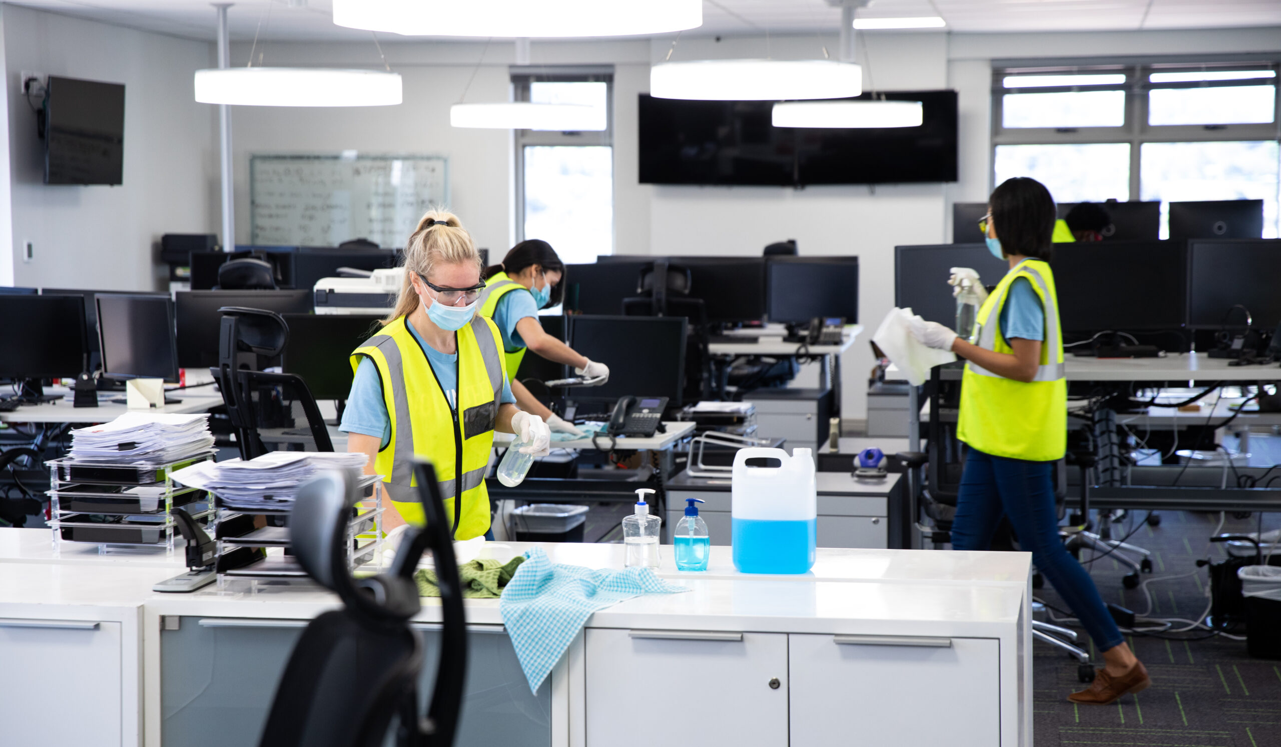 Professional crew in masks hard at work office deep cleaning
